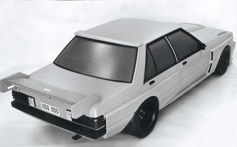 Vista trasera de un automóvil modificado con un diseño aerodinámico y spoiler grande.